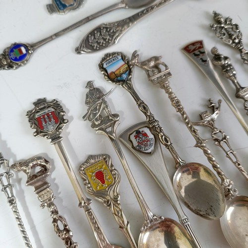 75 - Assorted silver coloured metal and other travel/commemorative spoons, some with enamel decoration