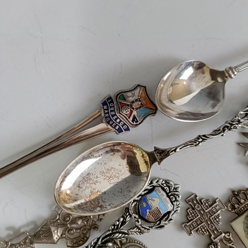 77 - Assorted silver coloured metal and other travel/commemorative spoons, some with enamel decoration