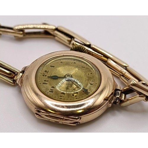 776 - A ladies 9ct gold wristwatch, with a Rolex movement, on a gold plated expandable strap