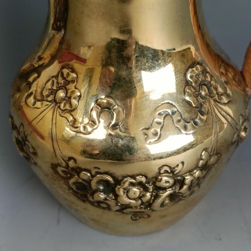 300 - A Continental gilt metal hot water jug, with embossed decoration, probably French, 11 cm high