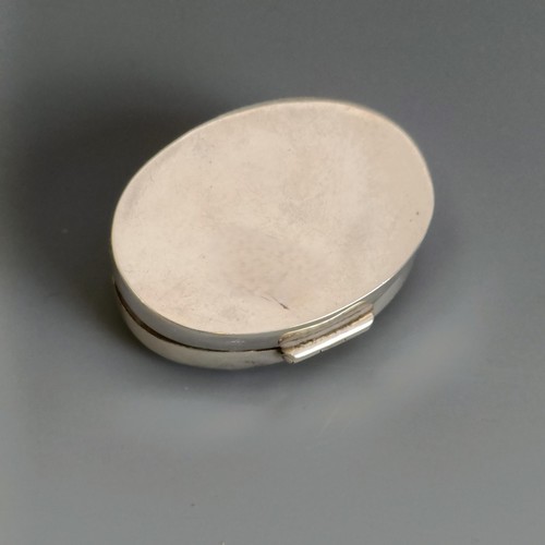 306 - An oval silver pill box, with engraved decoration