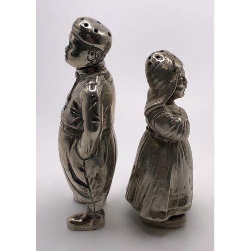 146 - A silver pepperette, in the form of a Dutch boy, 8 cm high, and a similar silver coloured metal pepp... 