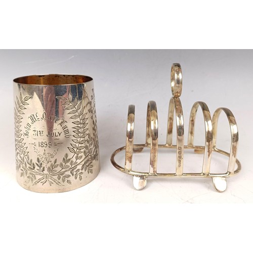 37 - A late Victorian silver christening mug, inscribed and dated 1899, and a silver toast rack, 5.5 ozt ... 