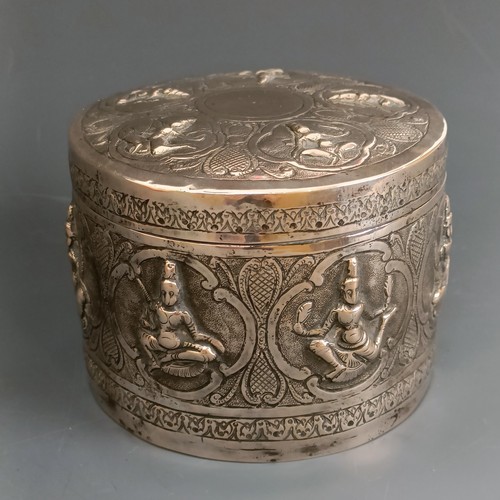 358 - An Indian or Burmese silver coloured metal box and cover, decorated deities, 11 cm diameter