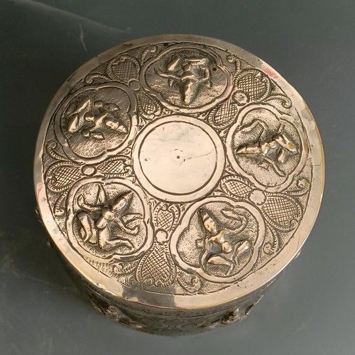 358 - An Indian or Burmese silver coloured metal box and cover, decorated deities, 11 cm diameter