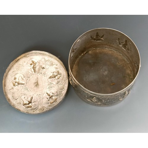 358 - An Indian or Burmese silver coloured metal box and cover, decorated deities, 11 cm diameter