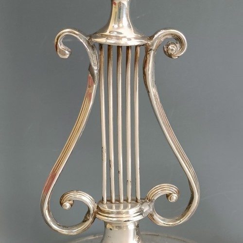 386 - A pair of silver candlesticks, of lyre form, marks rubbed, probably London 1929, 20.5 cm high