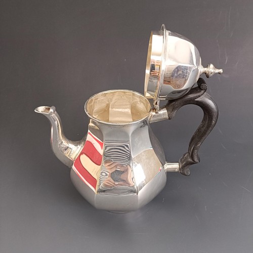 392 - An Edward VII silver three piece tea set, crested, the teapot with an ebonised handle, London 1904, ... 