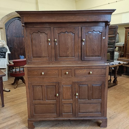 1317 - An oak buffet, the top having three cupboard doors, on a base with three drawers and two cupboard do... 