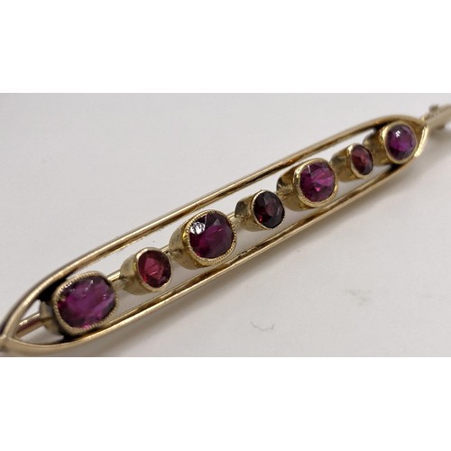 699 - A 15ct gold and ruby bar brooch, in a vintage jewellery box