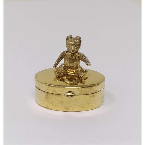 322 - A silver gilt novelty pill box, with a teddy bear finial, a floral brooch, and a bottle collar (3)