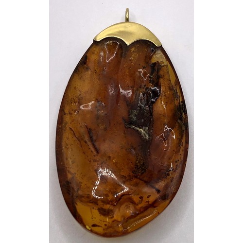 747 - A large amber pendant, on an 18ct gold mount