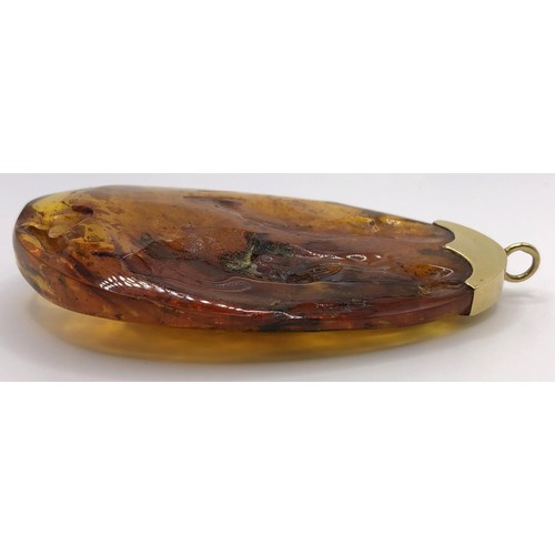 747 - A large amber pendant, on an 18ct gold mount