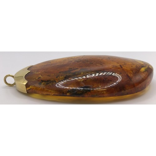 747 - A large amber pendant, on an 18ct gold mount