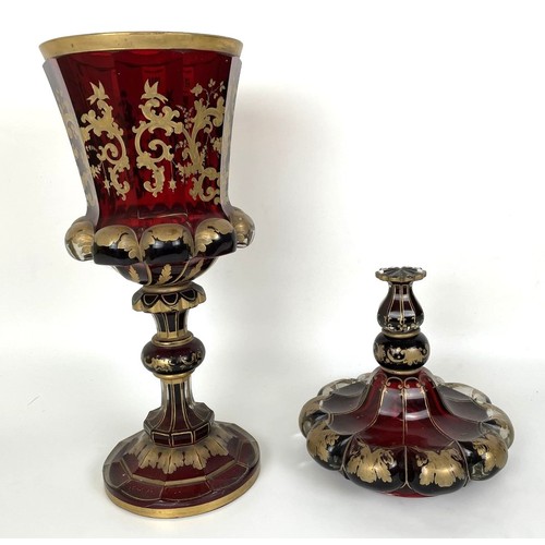 1059 - A large 19th century ruby glass goblet and cover, decorated in gilt, broken and repaired, gilt rubbe... 