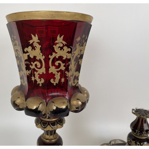 1059 - A large 19th century ruby glass goblet and cover, decorated in gilt, broken and repaired, gilt rubbe... 