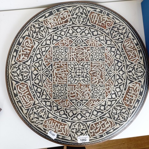 1082 - An Egyptian style charger, with silver coloured metal decoration, 51 cm diameter, a pair of pewter c... 