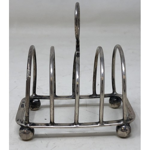 440 - A George V silver toast rack, a pair of silver sugar tongs, and assorted other silver items, 6.2 ozt... 