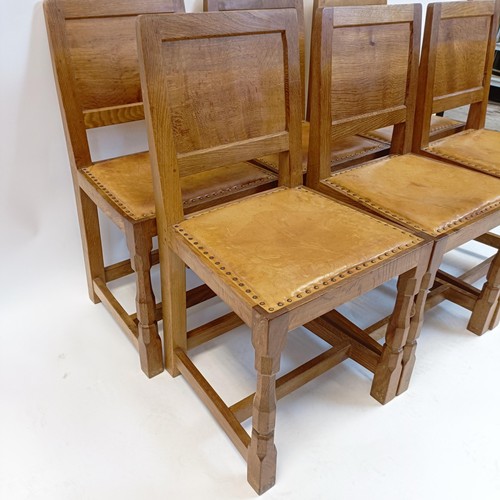 1206 - Robert Mouseman Thompson of Kilburn, a set of six oak panel back dining chairs, with studded leather... 