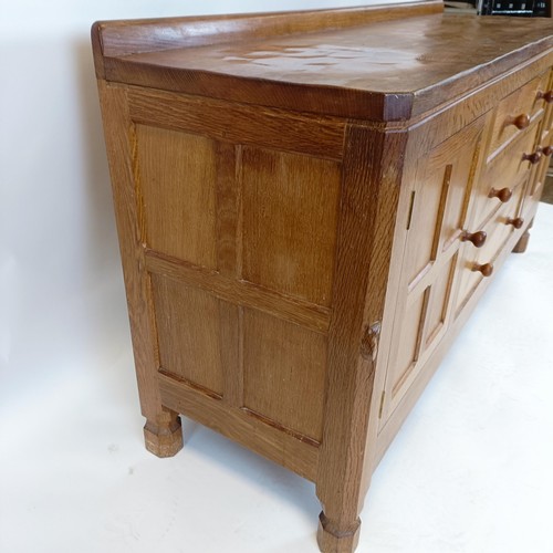 1215 - Robert Mouseman Thompson of Kilburn, a sideboard, with three central drawers, flanked by cupboard do... 