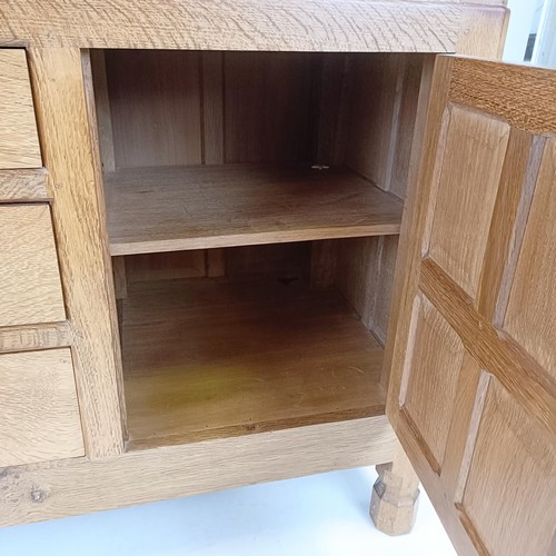 1215 - Robert Mouseman Thompson of Kilburn, a sideboard, with three central drawers, flanked by cupboard do... 