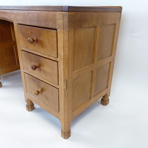 1219 - Robert Mouseman Thompson of Kilburn, a kneehole dressing table, having an adzed top, with six drawer... 