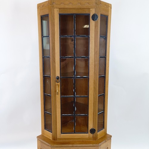 1224 - Robert Mouseman Thompson of Kilburn, a corner cupboard, the top with a leaded glazed door, flanked b... 