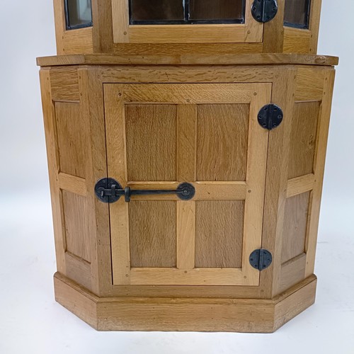 1224 - Robert Mouseman Thompson of Kilburn, a corner cupboard, the top with a leaded glazed door, flanked b... 