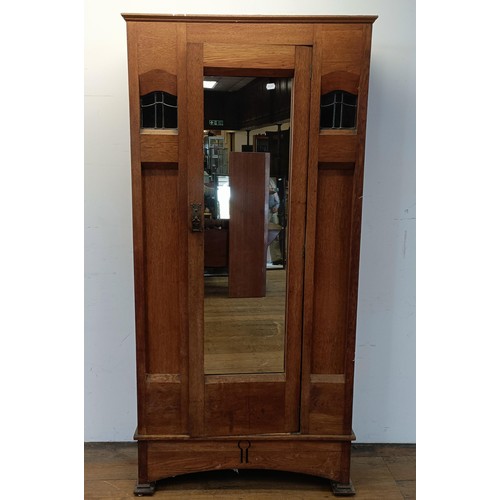 1240 - An Arts and Crafts single wardrobe, with a mirrored door, 195 cm high, 95 cm wide