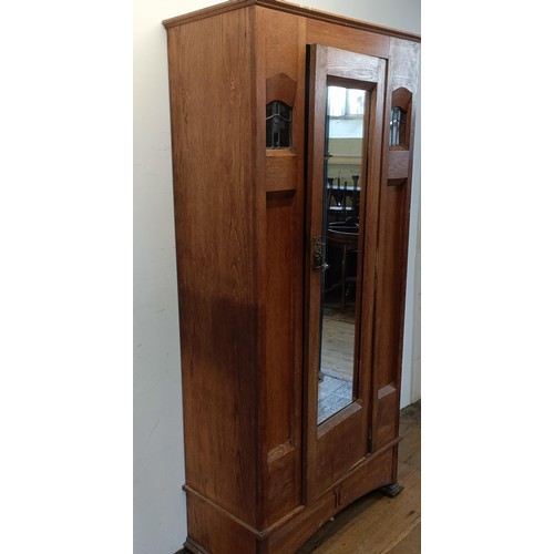 1240 - An Arts and Crafts single wardrobe, with a mirrored door, 195 cm high, 95 cm wide