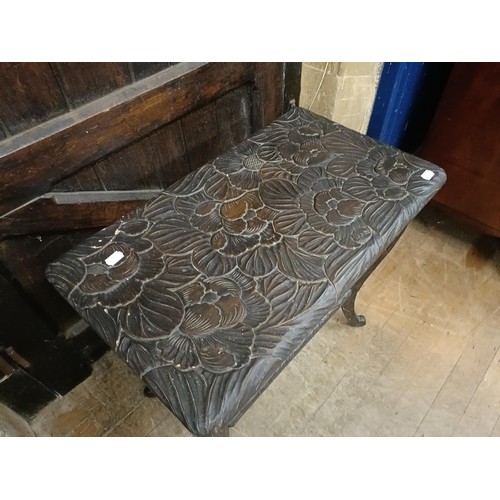 1303 - A Liberty style carved two tier table, decorated flowers, 73 cm wide