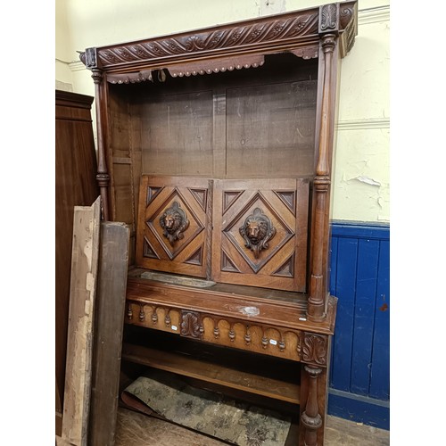 1305 - A 19th century walnut bookcase on cupboard, having open shelves above a pair of panel door carved li... 