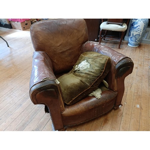 1308 - A 1920s brown leather easy chair, in need of restoration