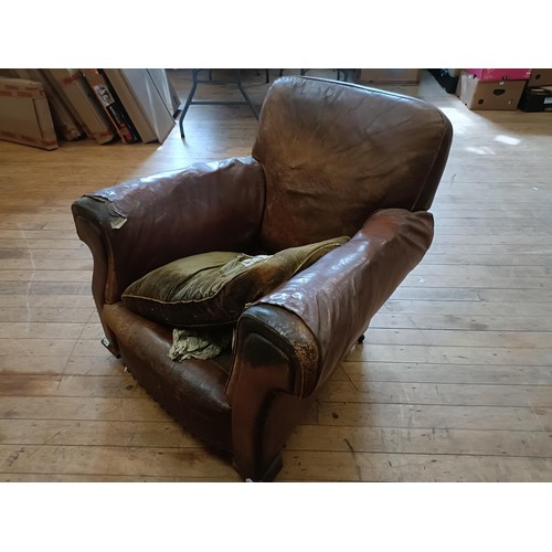 1308 - A 1920s brown leather easy chair, in need of restoration