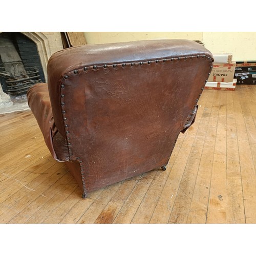 1308 - A 1920s brown leather easy chair, in need of restoration