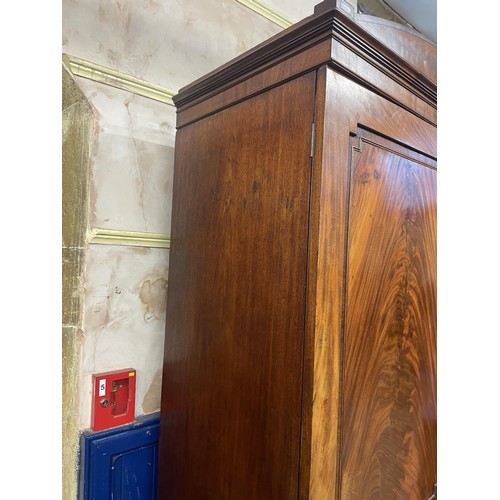 1327 - A 19th century mahogany linen press, with two cupboard doors, on a base with two short and two long ... 