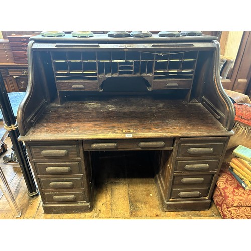 1262 - A large oak tambour fronted desk, 127 cm high, 132 cm wide