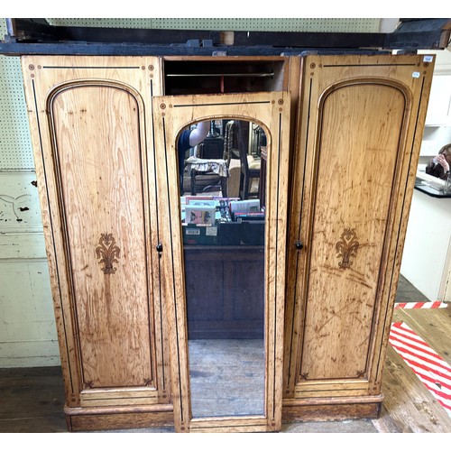 1242 - A Victorian pine triple wardrobe, with a central mirrored door and stencilled decoration, 180 cm wid... 