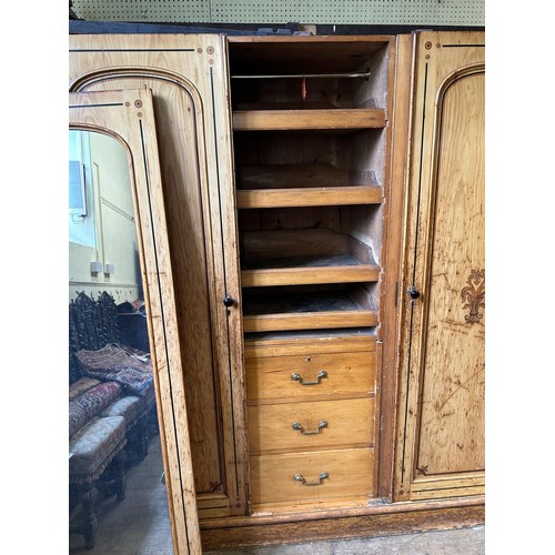 1242 - A Victorian pine triple wardrobe, with a central mirrored door and stencilled decoration, 180 cm wid... 