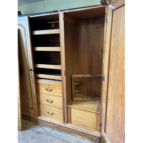 1242 - A Victorian pine triple wardrobe, with a central mirrored door and stencilled decoration, 180 cm wid... 