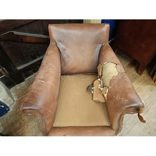 1386 - A 1920s brown leather easy chair, in need of restoration