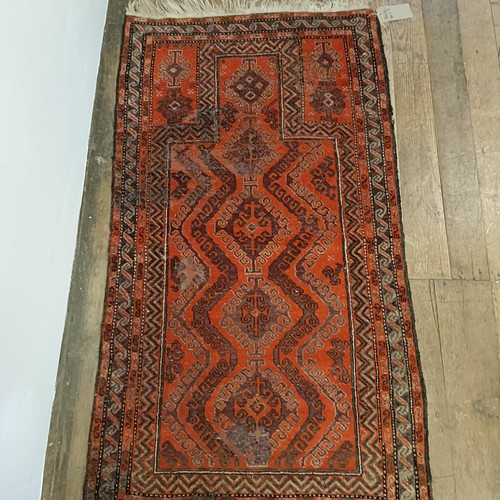 1241 - A red ground rug, 177 x 122 cm, another, 162 x 91 cm, and another, 202 x 125 cm, and a red ground ca... 