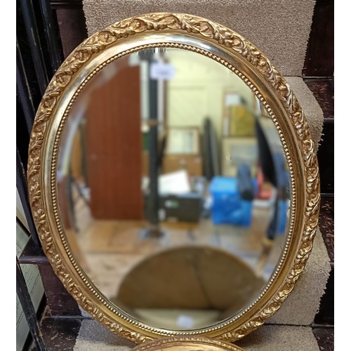 1380 - A gilt framed oval wall mirror, 45 x 40 cm, and another, 68 x 52 cm