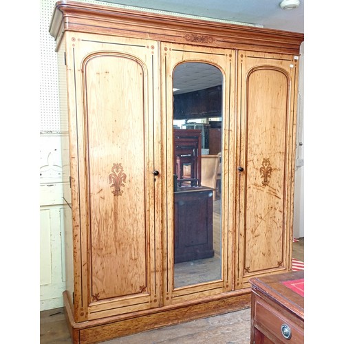 1242 - A Victorian pine triple wardrobe, with a central mirrored door and stencilled decoration, 180 cm wid... 