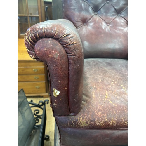 1318 - A late 19th/early 20th century leather button back armchair, on turned mahogany legs, worn, and an o... 