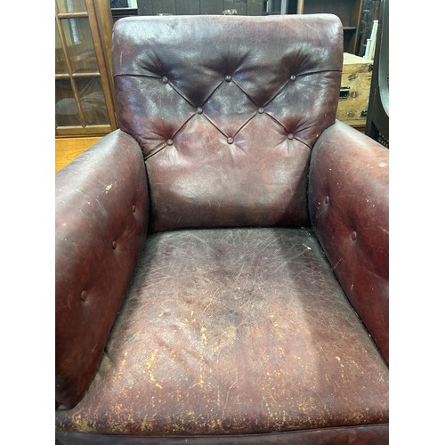 1318 - A late 19th/early 20th century leather button back armchair, on turned mahogany legs, worn, and an o... 