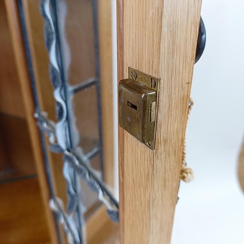 969 - Robert Mouseman Thompson of Kilburn, a corner cupboard, the top with a leaded glazed door, flanked b... 