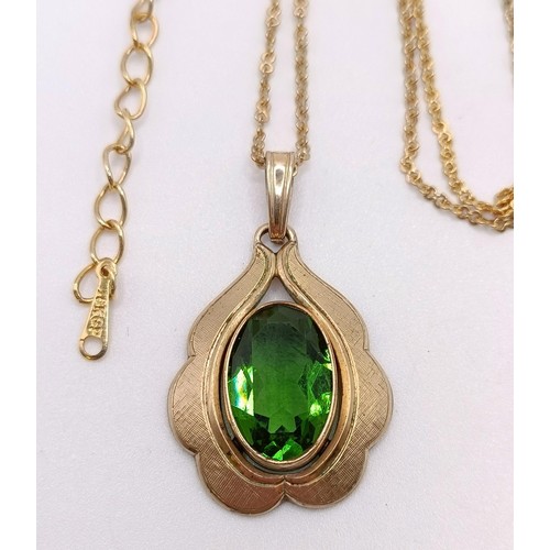 765 - A rolled gold and green stone pendant, on a gilt metal chain