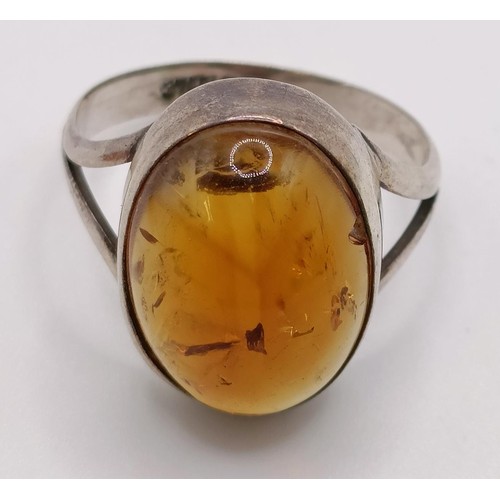 769 - A pair of silver and amber stud earrings, a similar ring, an amber coloured stone pendant (3)