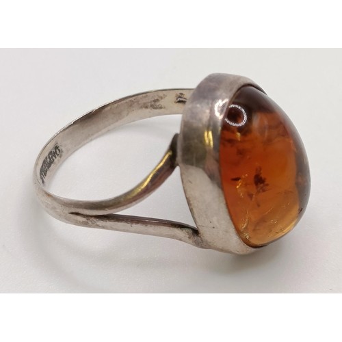 769 - A pair of silver and amber stud earrings, a similar ring, an amber coloured stone pendant (3)